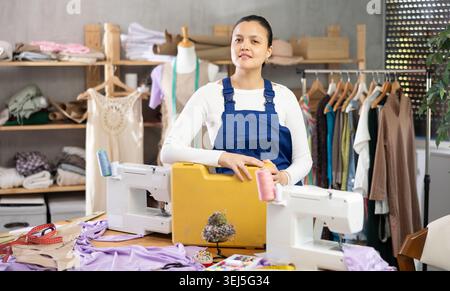 Woman sewing machine repairman standing in workshop Stock Photo