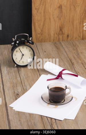 Old clock, hat, coffee and paper sheets on old Wooden table Stock Photo