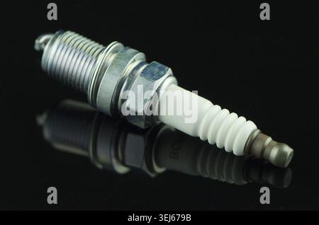 Spark-plug on black reflective background Stock Photo