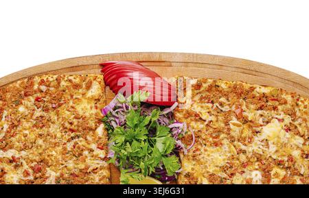 Food, Freshly baked flatbread with a savory topping of herbs, spices, and cheese is served on a wooden board, accompanied by sliced vegetables and gar Stock Photo