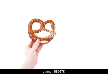 Woman's hand holding traditional Bavarian salty pretzel isolated over white background Stock Photo