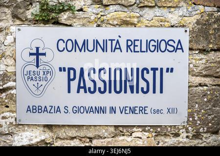 Vieste - Apulia - Italy - 08-29-2025: White sign with blue COMUNITA RELIGIOSA PASSIONISTI text, cross emblem, and abbey line is fixed to a rough ston Stock Photo