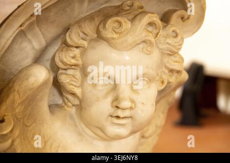 Sessa Aurunca - Campania - Italy - 08-29-2025: A close up of a carved marble cherub head with soft curls and small wings, showing smooth aged stone de Stock Photo