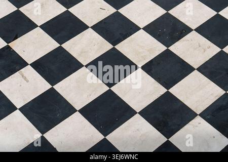 Black and white checkered floor tiles. Classic geometric pattern on polished stone. Clean lines define each square tile. Ideal for interior design pro Stock Photo