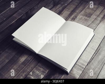 Photo of opened book with blank pages on wooden background. Vintage toned image Stock Photo