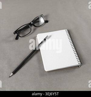 Blank notebook, glasses and pencil on craft paper background Stock Photo