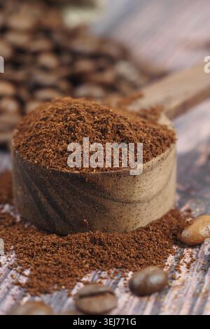 Freshly ground coffee sits in a wooden measuring scoop Stock Photo