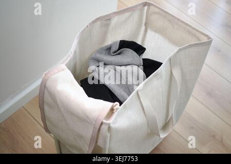 Laundry bag with clothes in a home setting Stock Photo