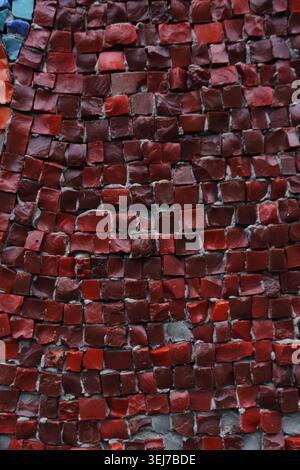 The wall is made of red bricks and has a rough texture. The pattern of the bricks is irregular and creates a sense of depth and dimension Stock Photo