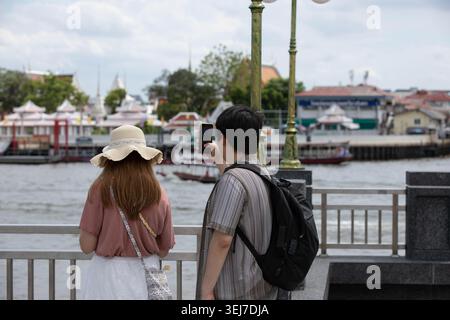 Tourist couple taking photo with smartphone, smartphone usage behavior during travel experience, rear view Stock Photo
