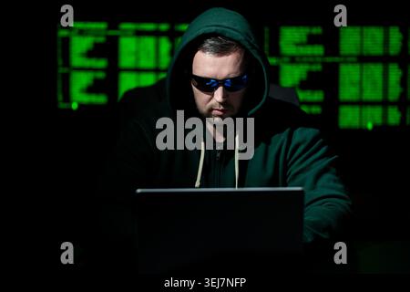 Hacker works on programming and coding. Hacker analyzes digital system vulnerabilities. Hacker monitors secure network infrastructure. Hacker attempts Stock Photo