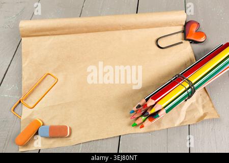 Craft supplies on a wooden table with colored pencils and paper for drawing activities Stock Photo