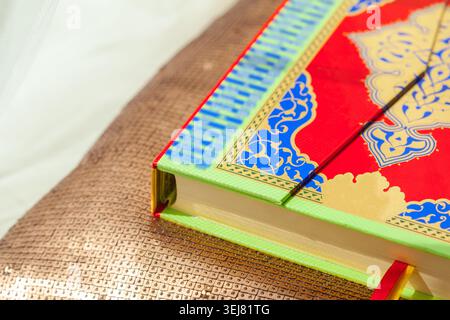 Colorful book with decorative cover placed on shiny surface in bright light during the day Stock Photo