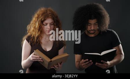 Young couple reading separate books, focusing on education and learning Stock Photo