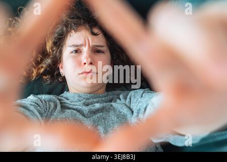 young red-haired woman relaxing on leather sofa Stock Photo