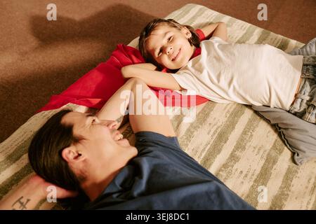 Father and Son Relaxing Together at Home for Family Lifestyle Stock Photo