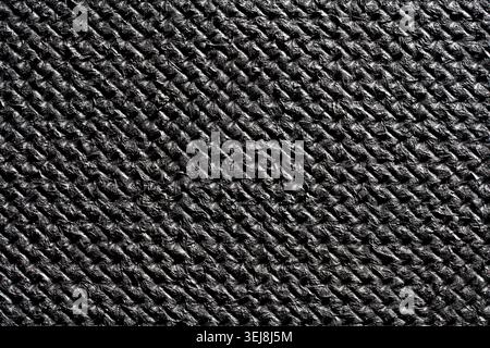 Close up of black woven carbon fiber texture or embossed dark synthetic material. Premium abstract background for automotive, tech, and sports product Stock Photo