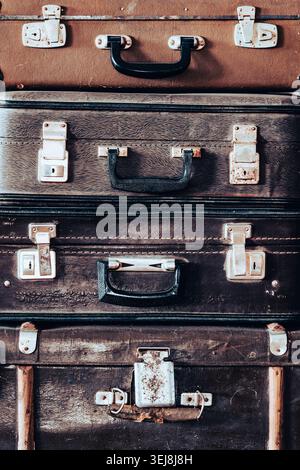 Stack of retro antique suitcases texture background. Close up of stacked old vintage suitcases with metal latches and handles. Nostalgic travel concep Stock Photo