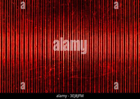 Macro shot of a classic retro automobile red rear light lens. Textured ribbed glass surface with scratches creates a vibrant vintage abstract backgrou Stock Photo
