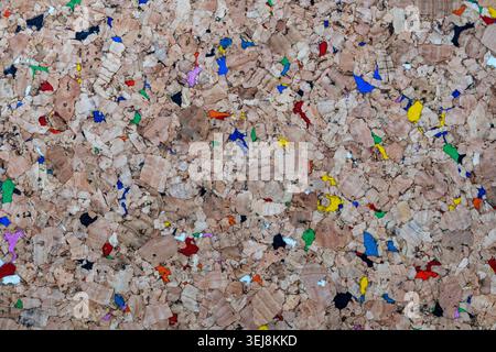 Colorful recycled cork texture, top view. Abstract background of natural brown cork wood texture with vibrant multicolored recycled rubber fragments Stock Photo