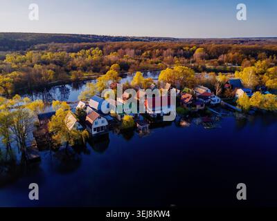 Flooded small village after river overflow. Concept of natural disaster, aerial drone view. Stock Photo
