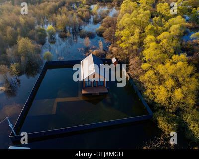 Flooded town house after river overflow. Concept of natural disaster, aerial drone view. Stock Photo
