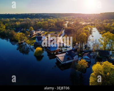 Flooded small village after river overflow. Concept of natural disaster, aerial drone view. Stock Photo