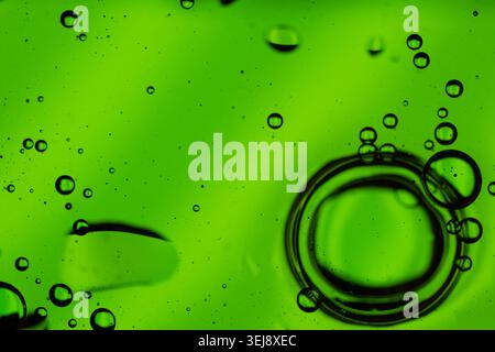 Close-up of dynamic air bubbles floating in a vibrant green textured fluid background Stock Photo