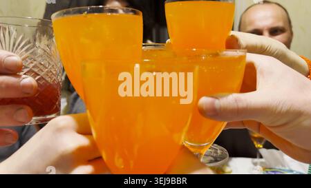 Female and male hands holding glasses gather in center as they toast together during festive gathering. The glasses clink, capturing joyful moment of Stock Photo