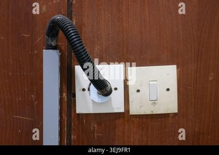 Electrical Outlet and Light Switch on Wooden Wall with Cable Conduit, Residential Wiring and Electrical Installation Concept Stock Photo