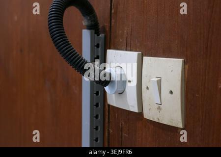 Electrical Outlet and Light Switch on Wooden Wall with Cable Conduit, Residential Wiring and Electrical Installation Concept Stock Photo