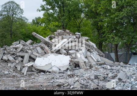 Heap of broken concrete pieces and exposed steel rebar at a demolition site. Stock Photo