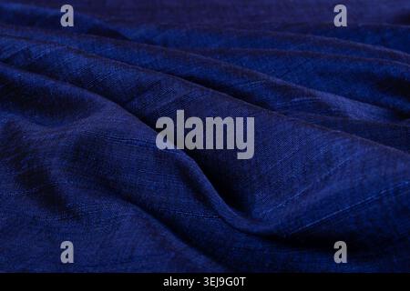 Close-up of luxurious royal blue matka silk fabric with natural slub texture and elegant folds, showcasing handcrafted silk textile craftsmanship. Stock Photo