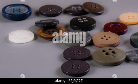 Collection of assorted clothing buttons arranged on a white background, used in tailoring, garment manufacturing and fashion accessories. Stock Photo