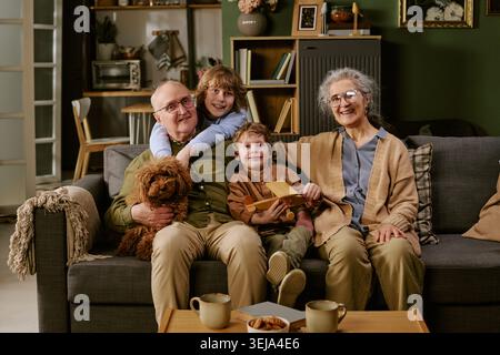Portrait of Senior Couple with Grandchildren Relaxing at Home Stock Photo