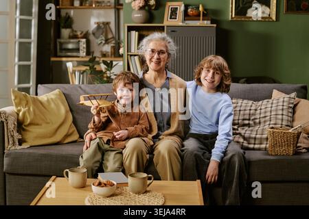 Portrait of Senior Woman Sitting with Grandsons at Home Stock Photo