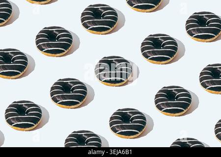 Chocolate donut pattern on white background. Creative food concept. Delicious dessert design idea. Stock Photo