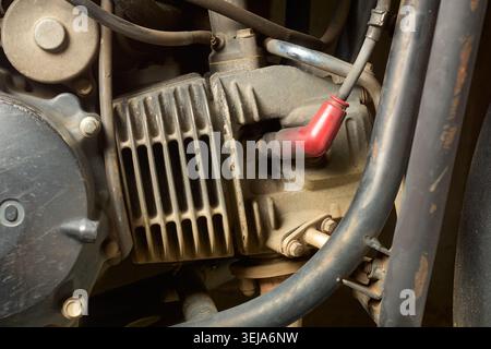 dirty metal motorcycle engine block with spar plug, dusty mechanical vehicle parts with cooling fins, close-up side view of automotive repair concept Stock Photo