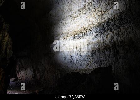 Illuminated stone wall in a cave in Apuseni Mountains, Romania Stock Photo