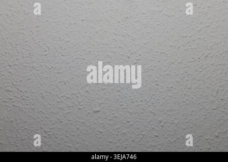 White textured stucco wall surface background creating pattern Stock Photo
