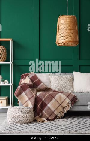 Interior of living room with sofa and knitted blanket Stock Photo