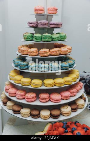 Colorful macarons stack elegantly on tiered stand Stock Photo