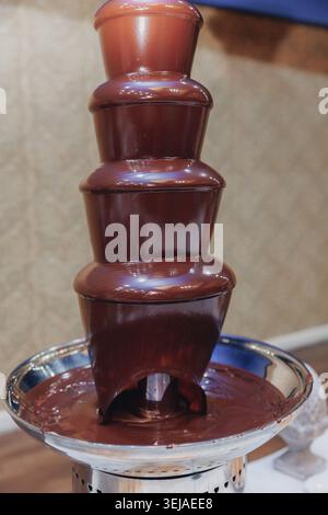 Rich chocolate cascades down a tiered fountain Stock Photo