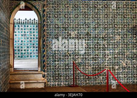 An ornate interior wall covered in detailed Portuguese azulejo tile patterns frames a decorative arched opening. Stock Photo