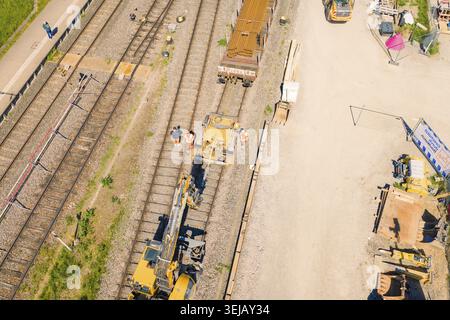Aerial view of construction workers and machines on a railroad track in sunny weather, electrification of the Hochrheinbahn, conversion of the station Stock Photo