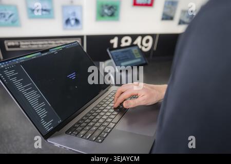 Person working on a laptop in a room with modern technologies and murals in the background, museum robot Robolutions, Marchivum, Mannheim, Germany Stock Photo