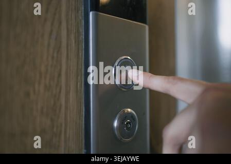 Human finger pushing up arrow button on elevator control panel, indicating starting journey, aiming for progress and growth, using modern technology f Stock Photo