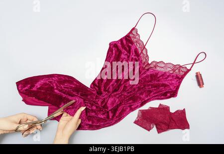 The process of manually sewing linen. Accessories for sewing. Scissors in the hands of a tailor close-up. The apartment was lying. Copy space. Flat la Stock Photo