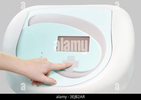 Futuristic medical device interface with human hand pressing touch screen button on modern equipment Stock Photo