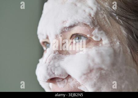 Caucasian female adult with facial foam, skincare routine, close-up of relaxed expression, wellness concept Stock Photo